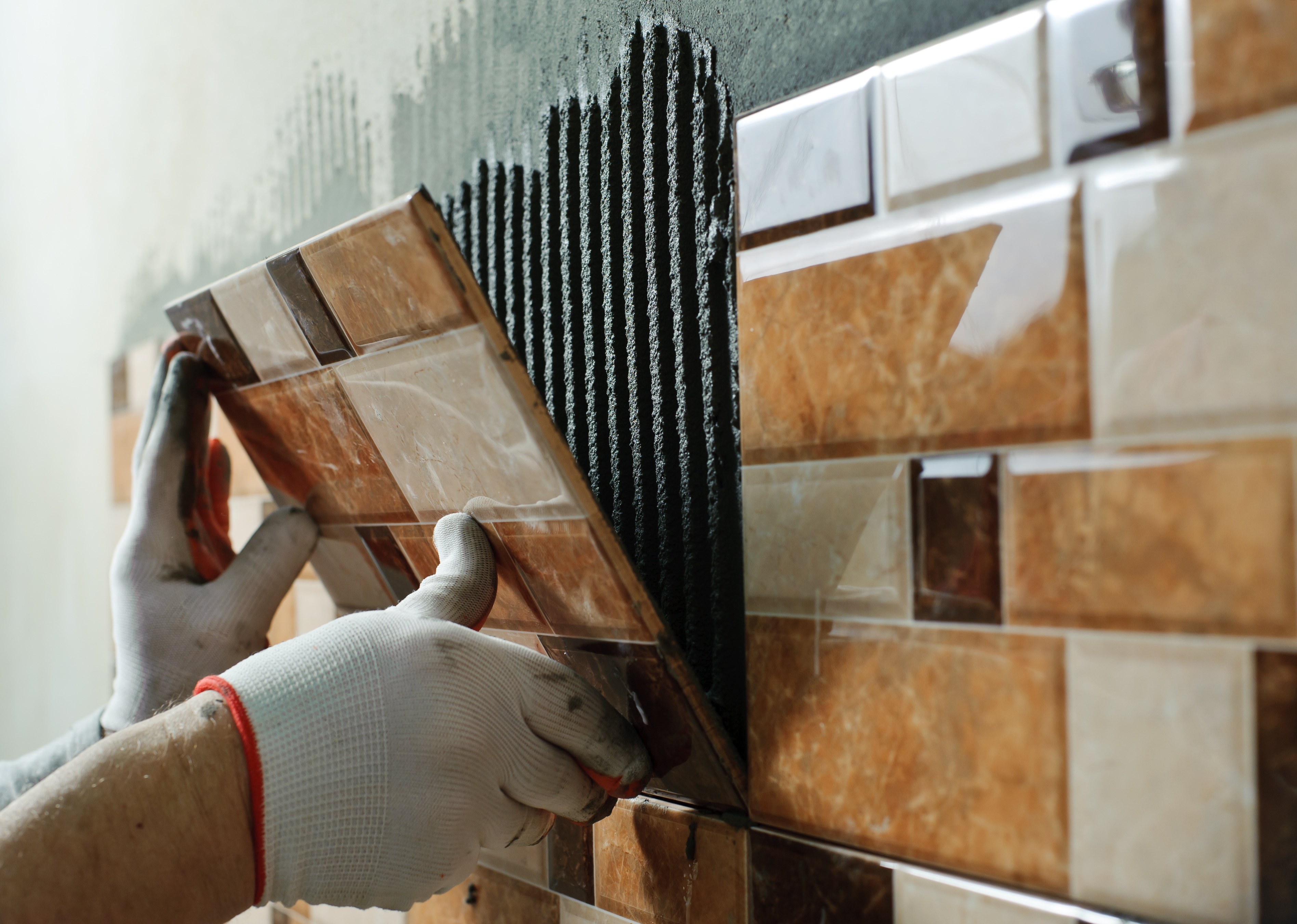 Construction Worker Fixing Tiles on Wall