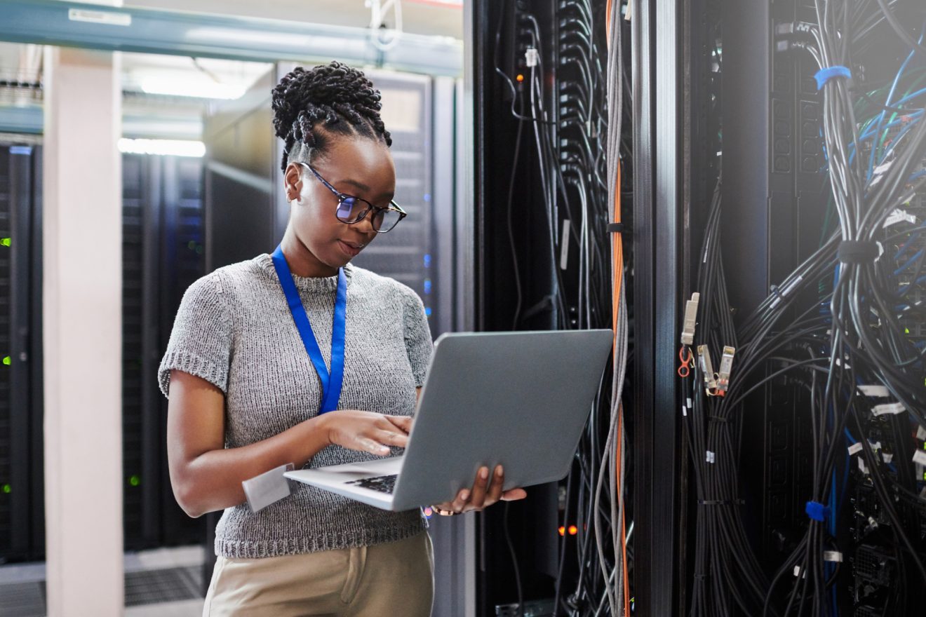 woman on laptop in room with computer servers