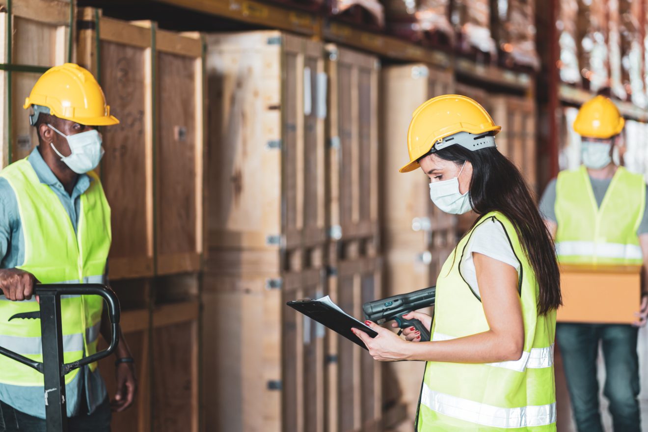 People in hardhats and safety vests in warehouse