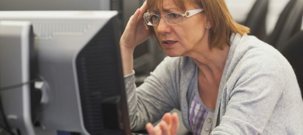 Angry mature student working with computer