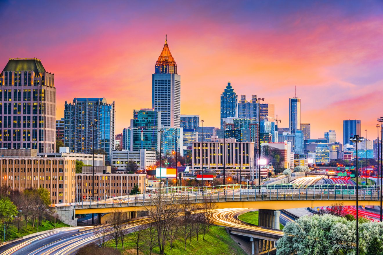 The Atlanta, Georgia skyline in front of a bright pink sunset.