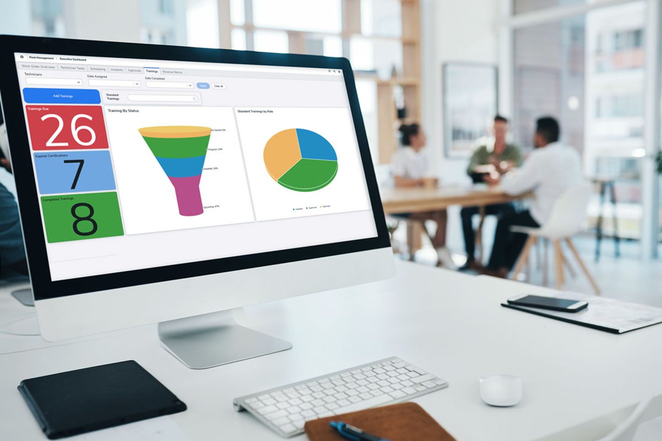 Quickbase app with funnel and pie chart on monitor in office