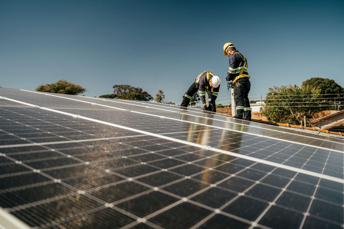 Men with hard hats installing solar panels