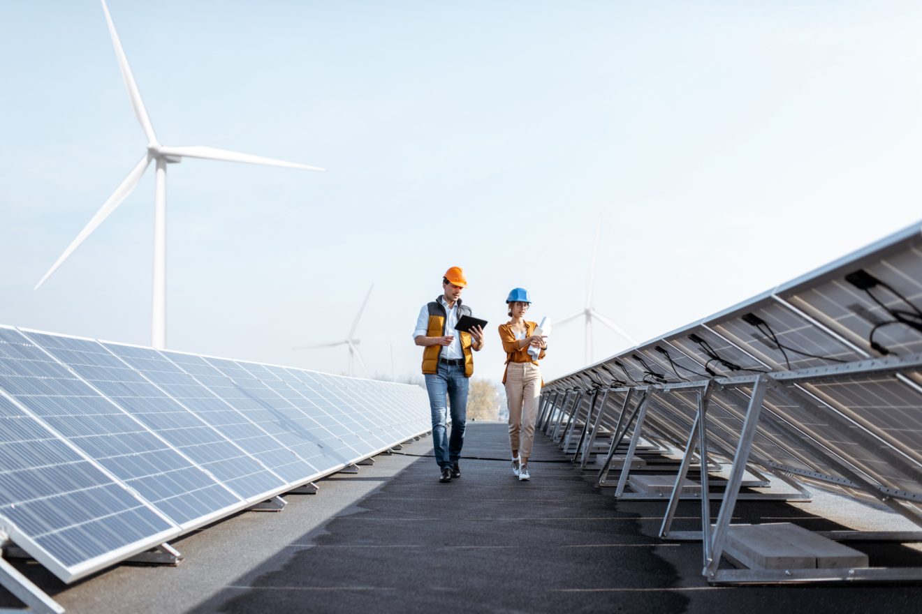 Two people walk through a renewable energy field