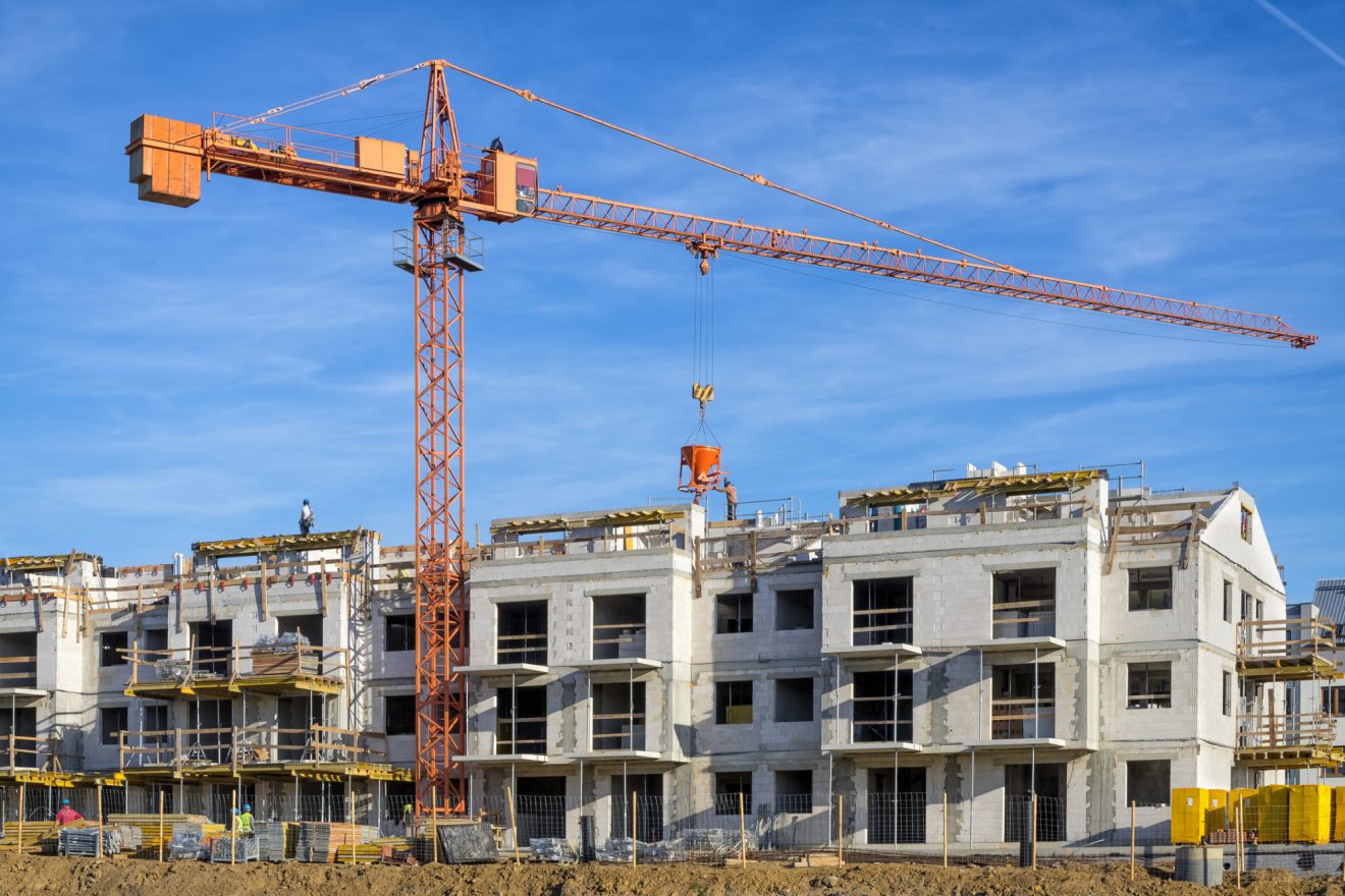 A crane towers over half-built town houses at a construction site