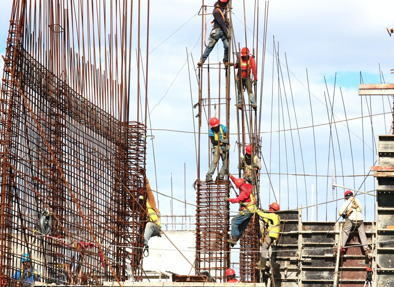 Construction workers climb scaffolding