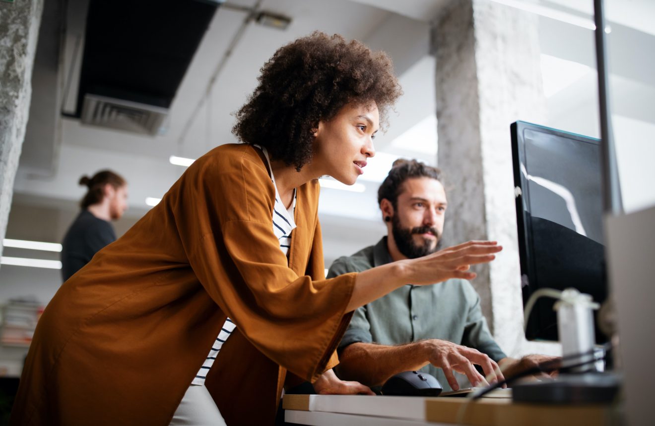 Woman and man on laptop discussing