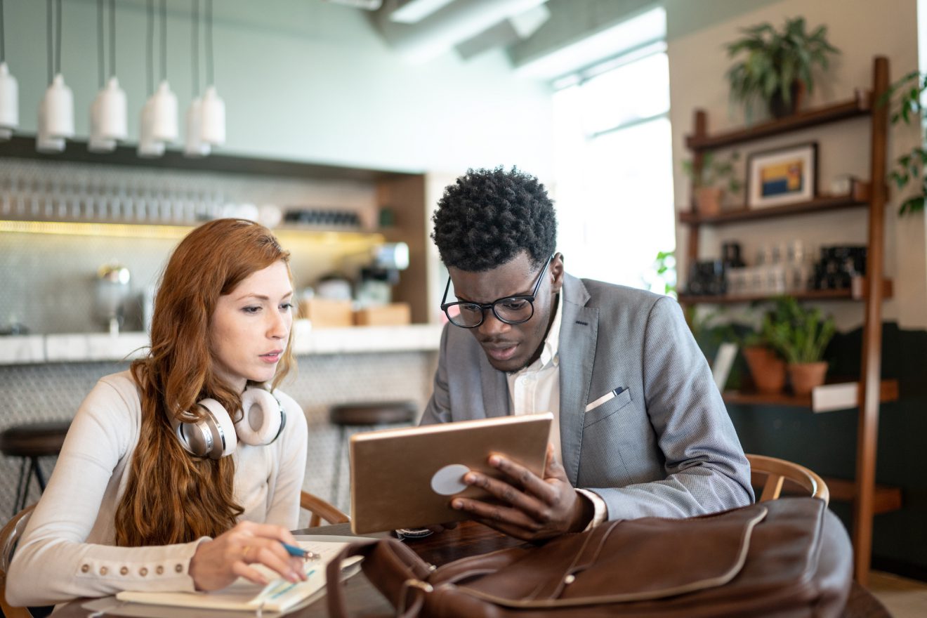 A pair of people referencing a tablet